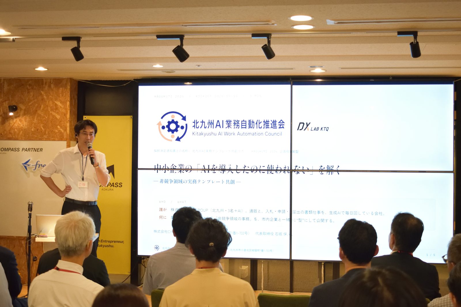 採択者ピッチで登壇する当社代表。スクリーンには当会のロゴと表題